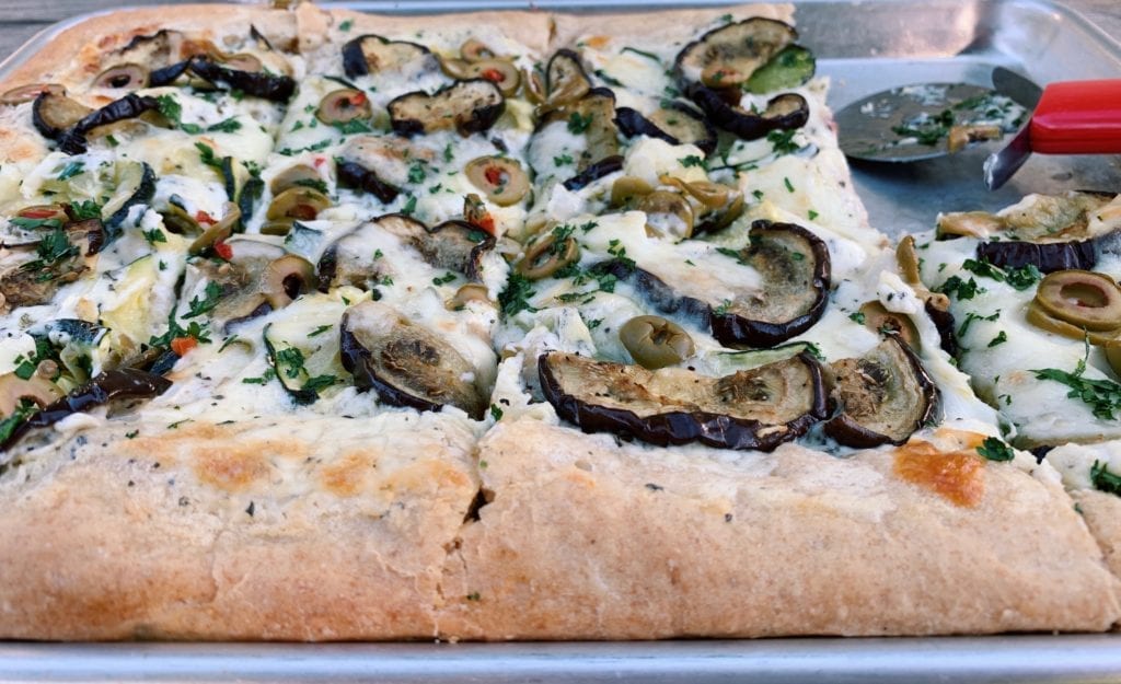 side view of eggplant pizza with creamy romano sauce 