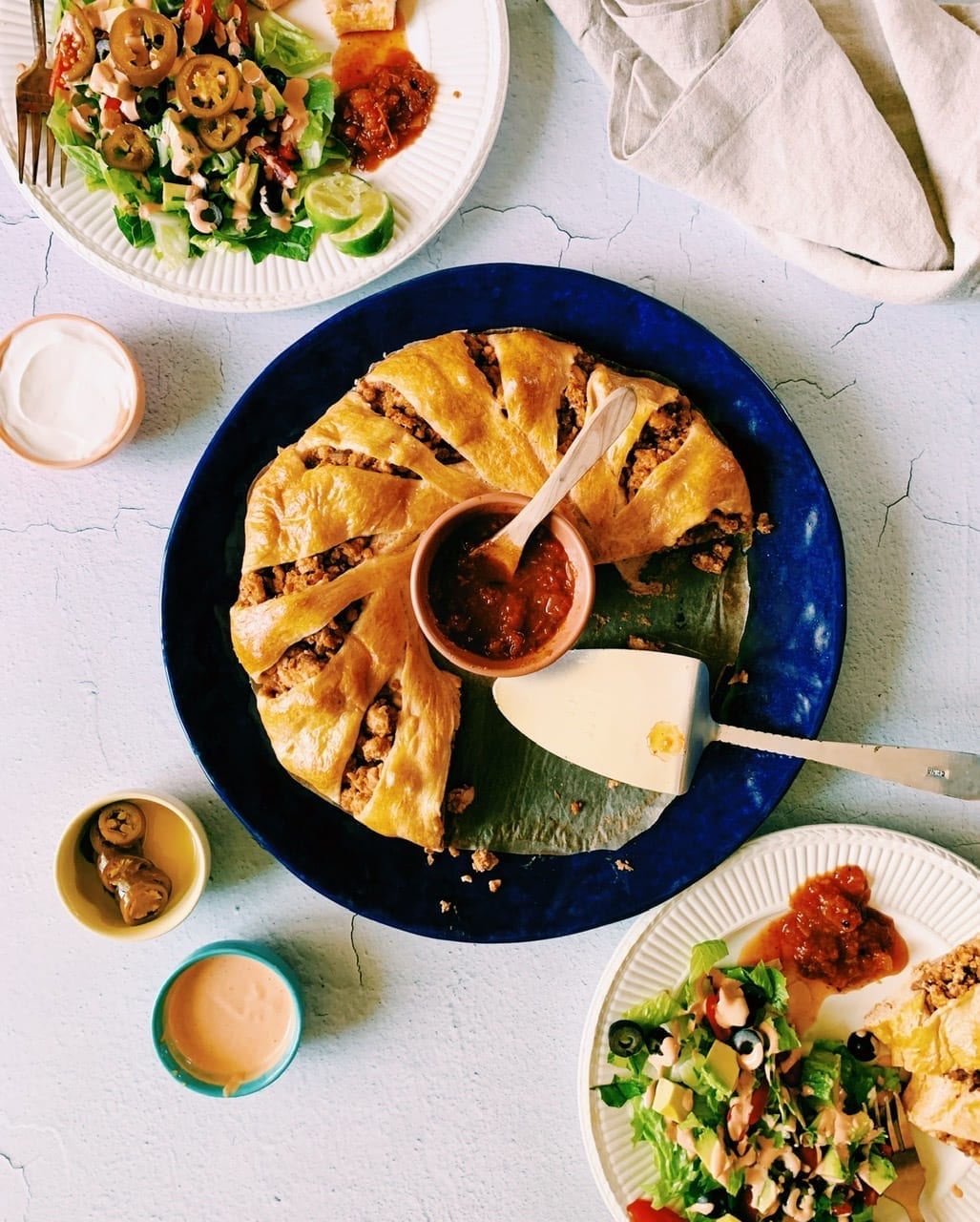 Overhead shot of crescent roll taco ring on blue plate