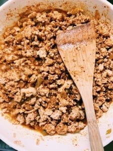 Ground chicken with taco seasoning in a skillet