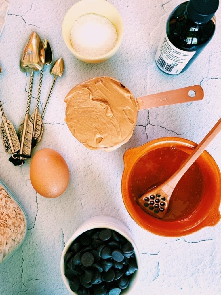 Sea salt, peanut butter, vanilla and oats on a counter top