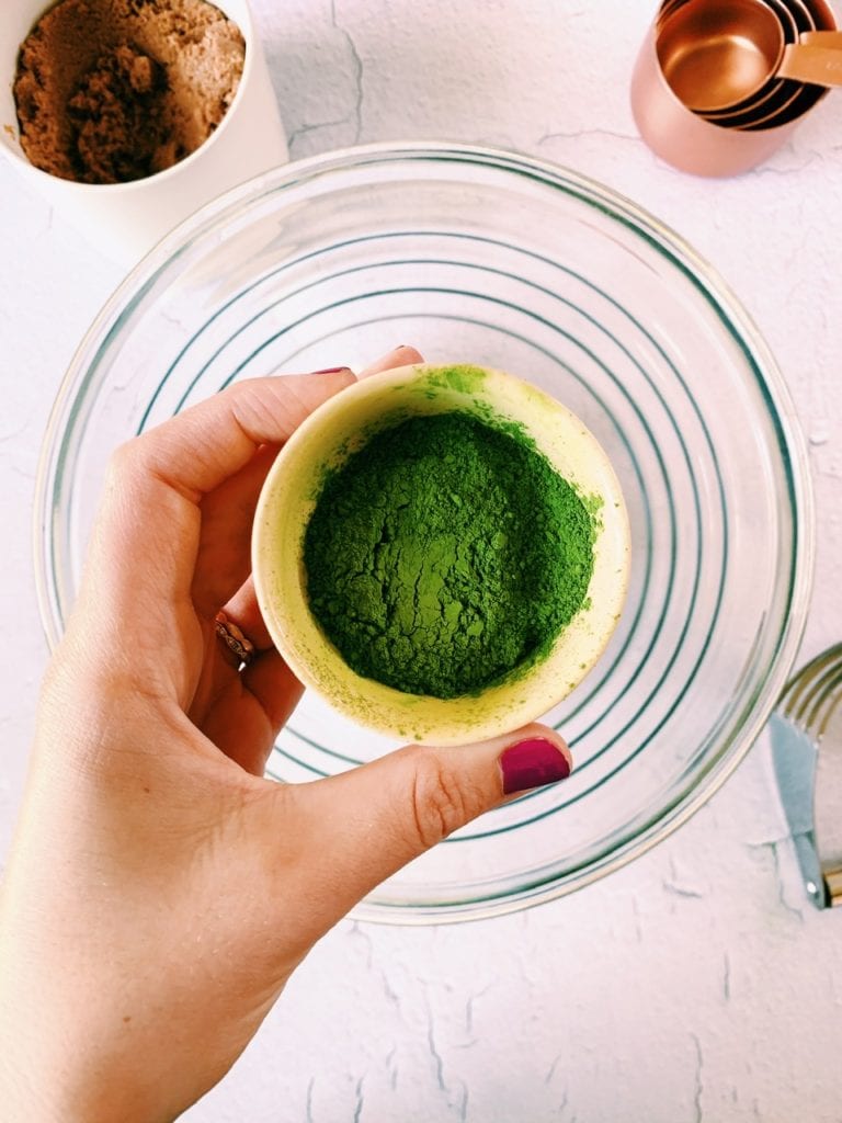 Overhead shot of matcha green tea powder in a small bowl. 