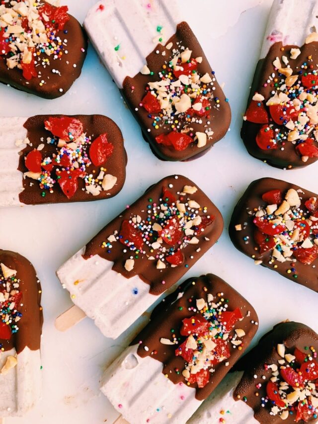 Overhead photo of banana split popsicles on a marble board