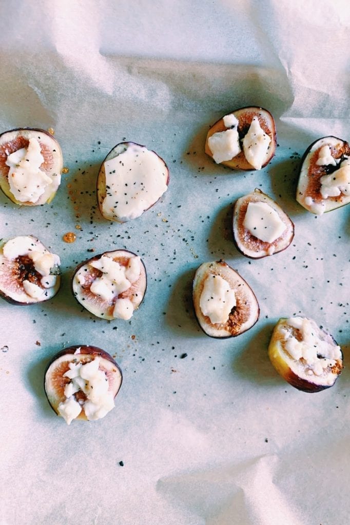 Close up of fig and honey goat cheese bites on parchment paper