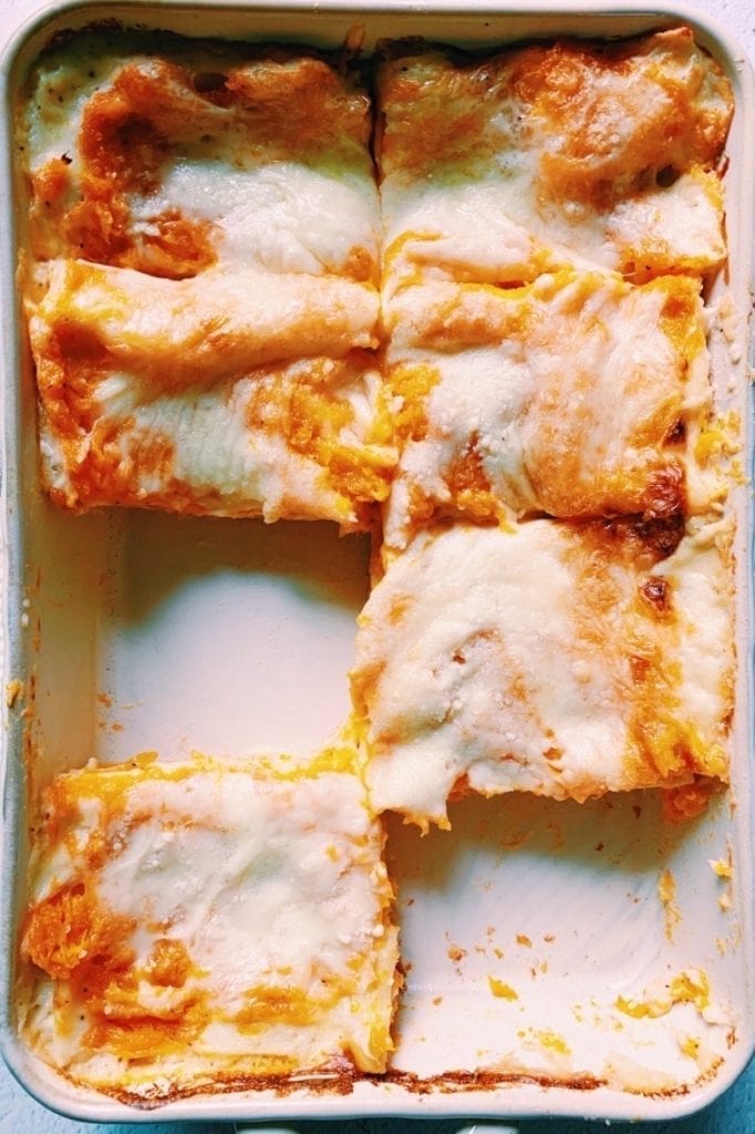 Butternut squash lasagna in baking dish with 2 pieces missing. 