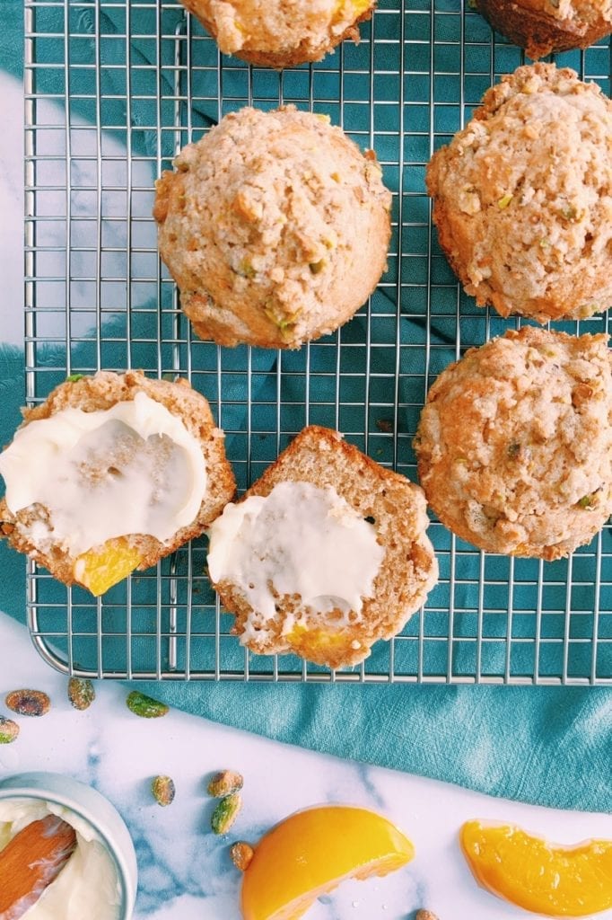 Overhead shot of peach cardamom muffins with pistachio crumble on a cooling rack. 