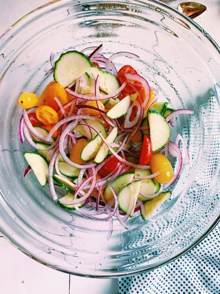 Cucumber, tomato and onion salad in a glass bowl for mediterranean rice bowls