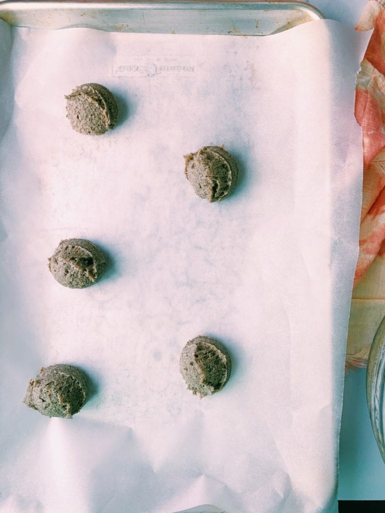 Cookie dough on a parchment lined baking sheet.