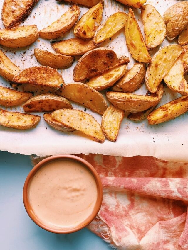 Yummiest potato wedges on a parchment lined baking sheet