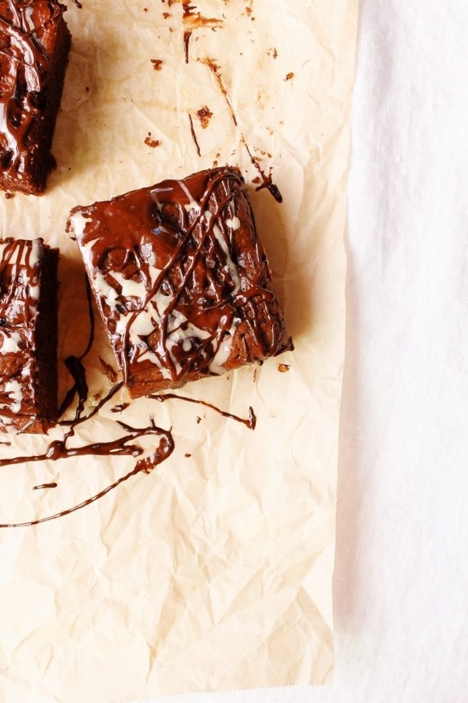 Close up of one tahini brownie on parchment paper 