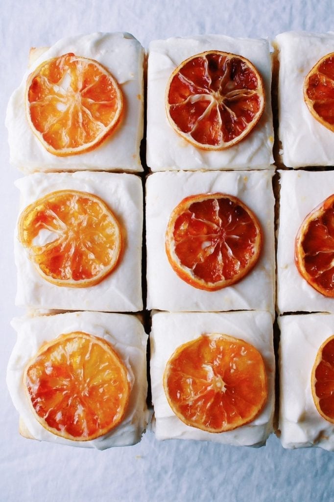 Overhead shot of lemon cake with cream cheese frosting topped with candied lemons