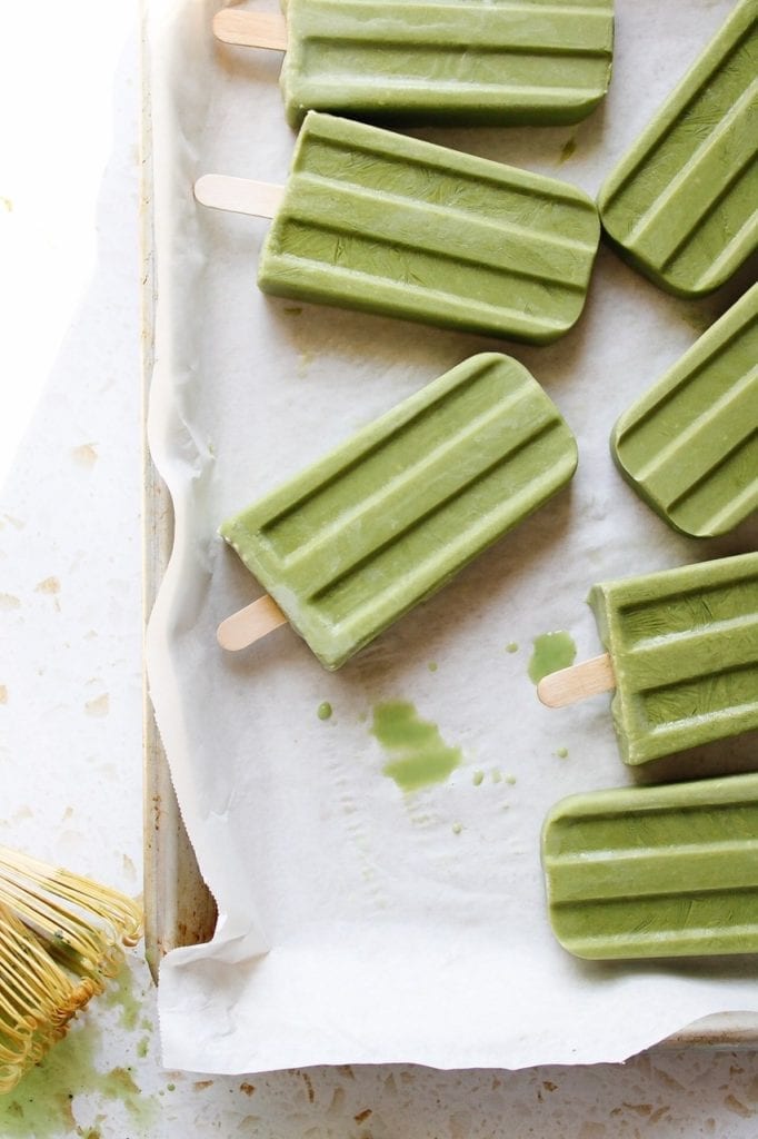 Matcha popsicles on a parchment lined tray