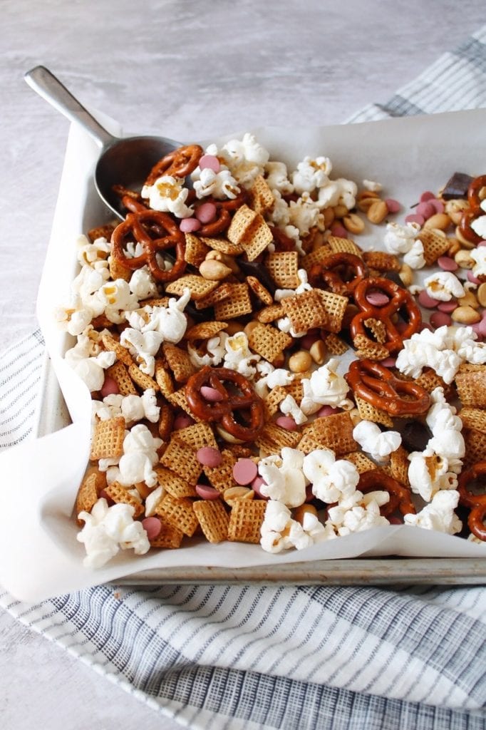 sweet and salty chex mix with a metal scoop