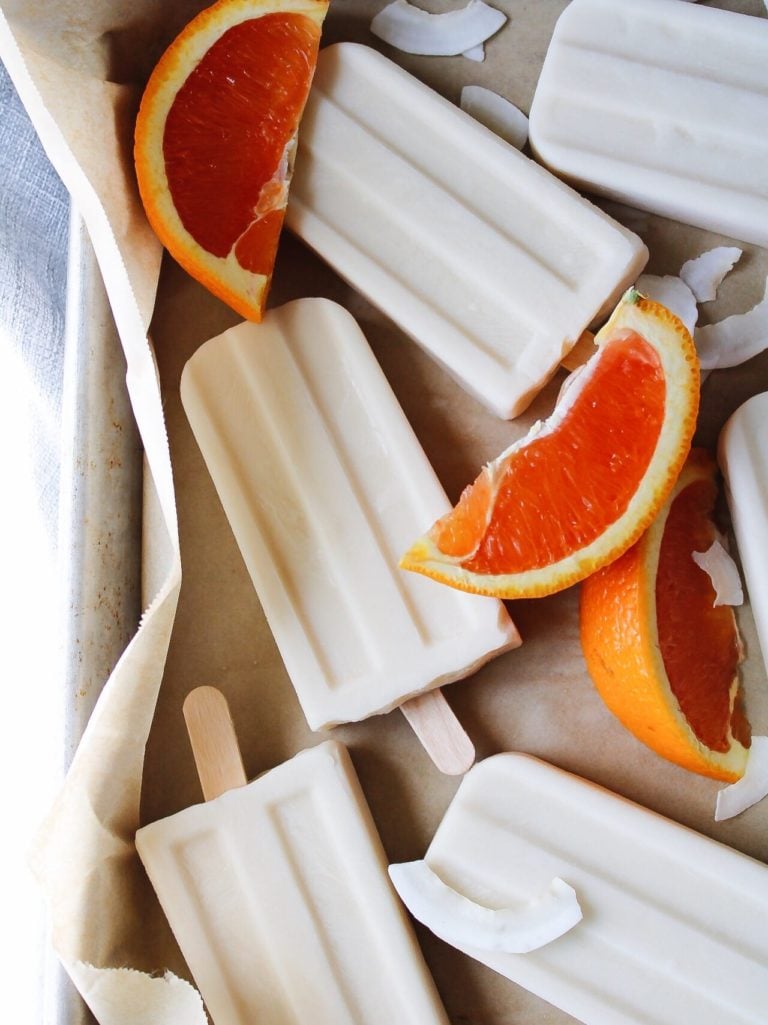 orange coconut milk popsicles on parchment paper