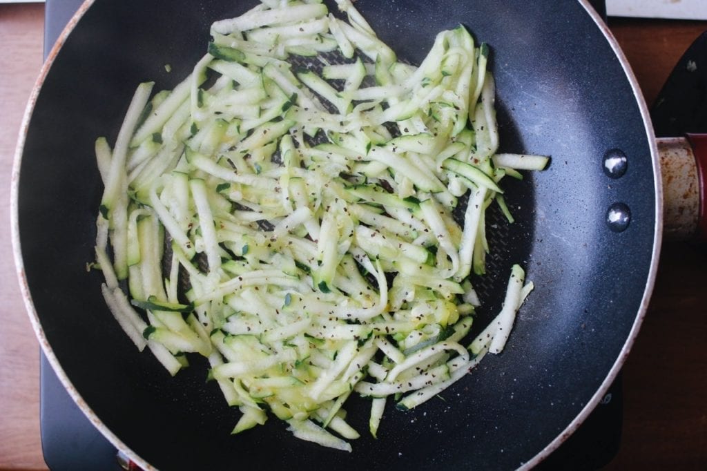 shredded zucchini in a pan with non-stick spray