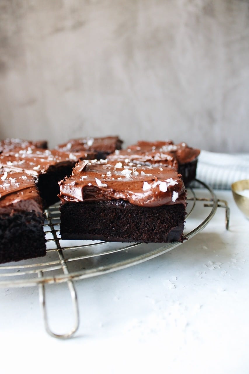 Side view of espresso sea salt frosted brownies on a cooling rack