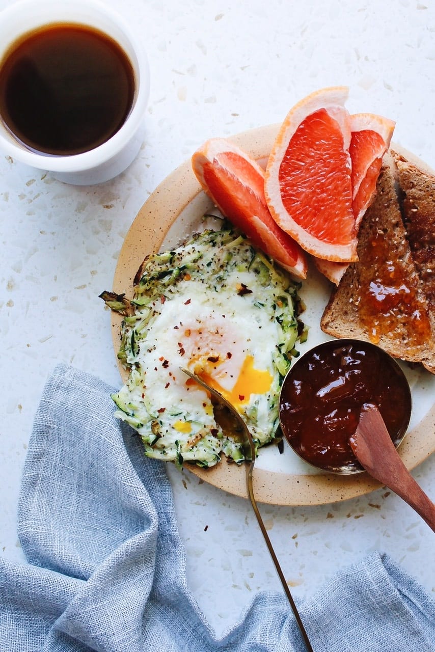 zucchini egg nest on a breakfast plate with toast and grapefuit