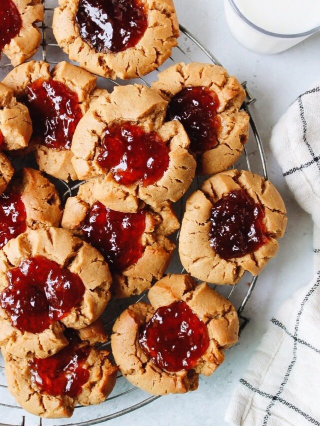 peanut butter and jelly thumbprint cookies on a cooling rack