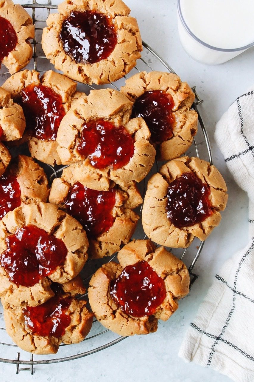 peanut butter and jelly thumbprint cookies on a cooling rack