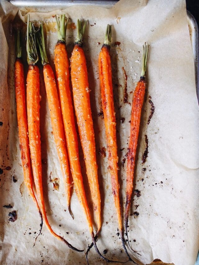 roasted carrots with honey, ginger and garlic on a baking sheet