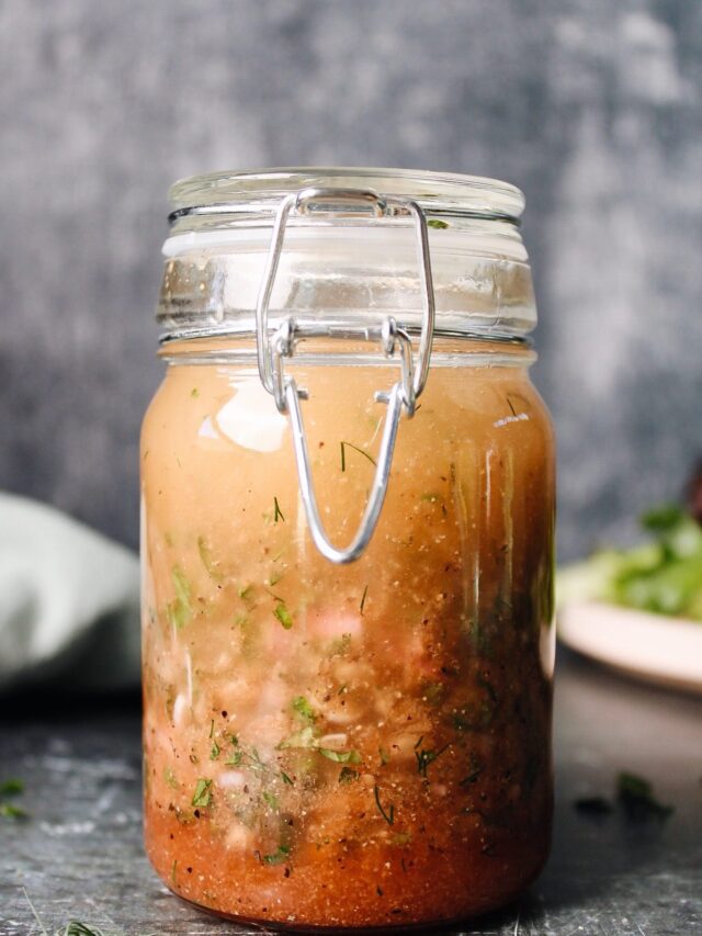 red wine shallot vinaigrette in a glass jar next to salad