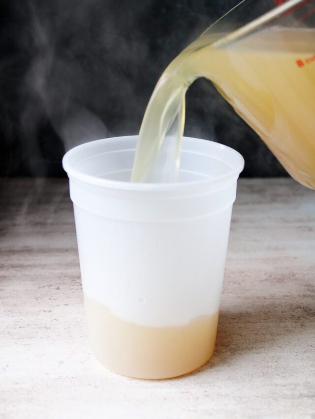 homemade chicken stock being poured into a plastic container