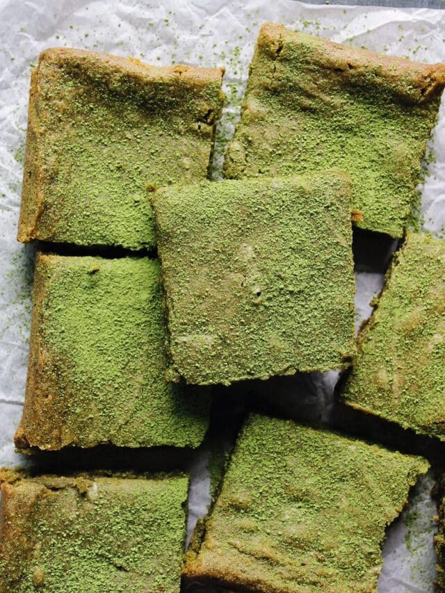 matcha brownies dusted with matcha green tea powder on parchment paper