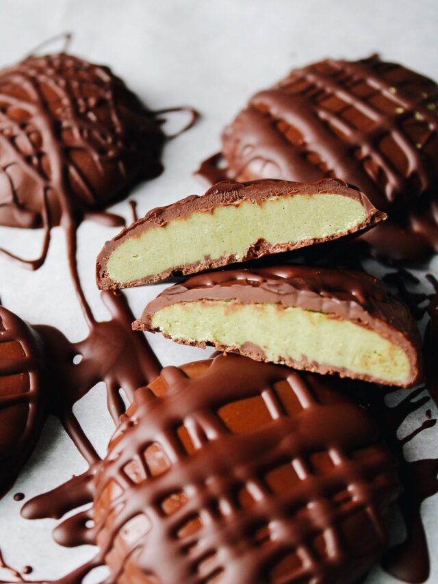 matcha cream chocolate truffles on parchment, one is cut in half to show the creamy matcha center