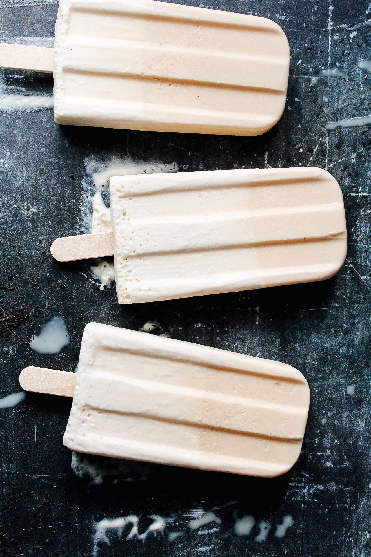 Tasty Homemade Ice Creams Pop With Sticks In Containers On Grey