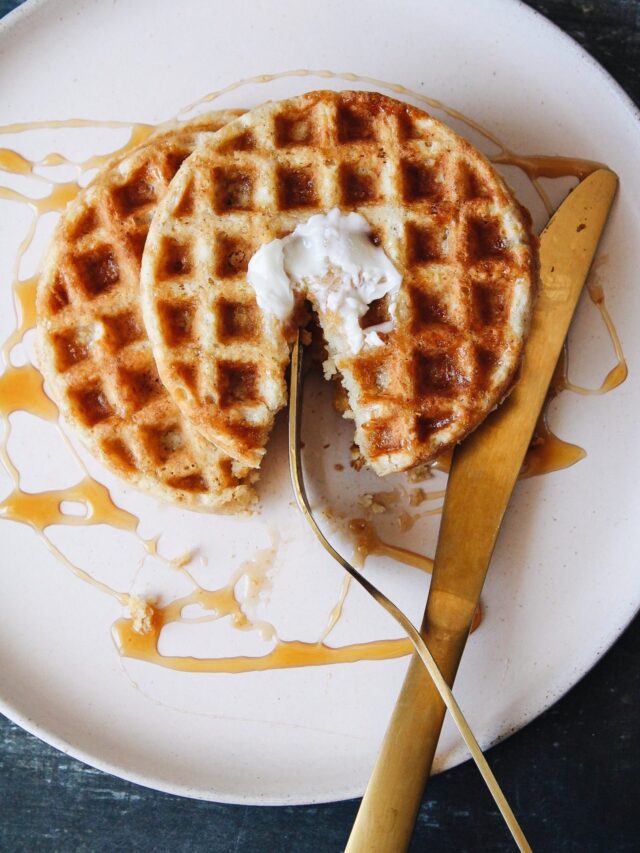 oat flour waffles on a beige plate with butter and syrup