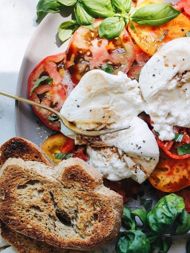 caprese burrata on a gray plate with garlic toasts