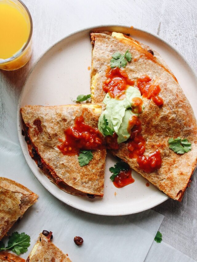 breakfast quesadillas topped with salsa and avocado creama