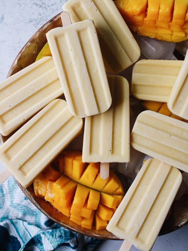 mango popsicles on a bowl of ice