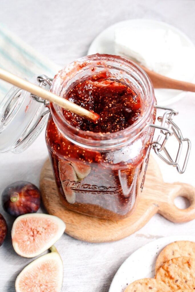 fig jam in a jar on a wooden coaster