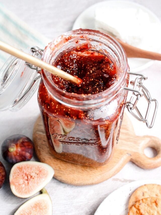 fig jam in a jar on a wooden coaster