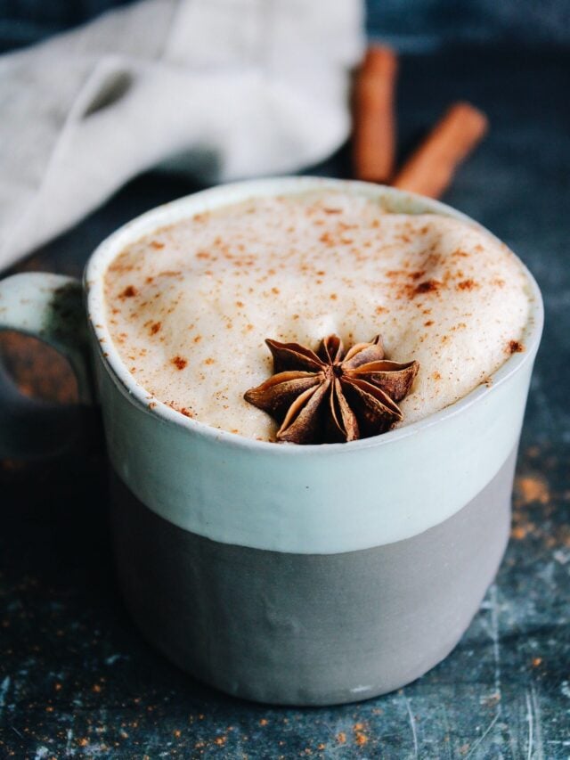 pumpkin chai latte in a striped mug topped with anise