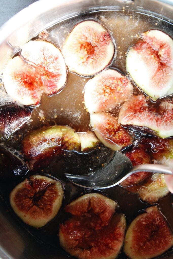 figs in sugar and water being broken up with a spoon