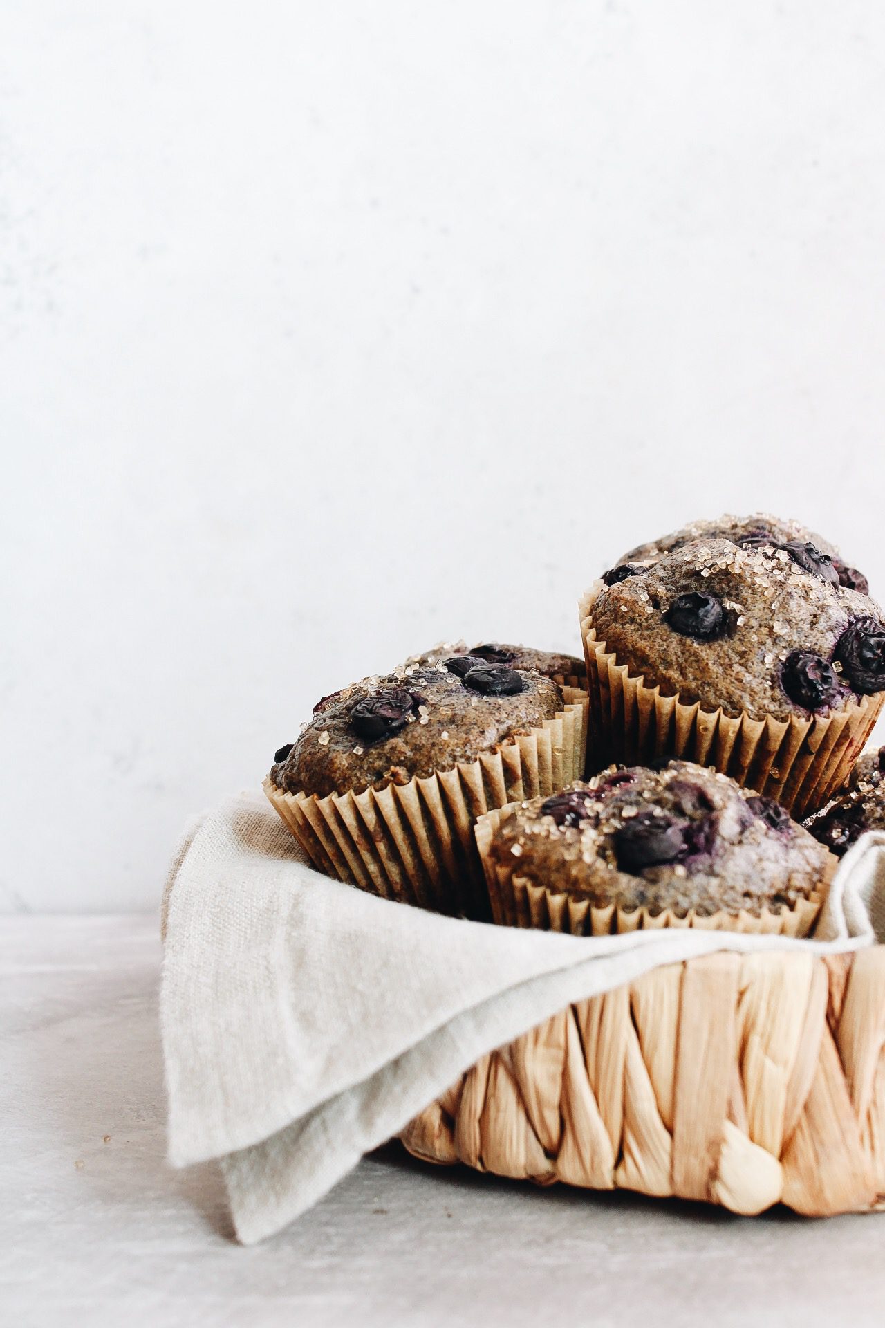 blueberry buckwheat muffins stacked in a straw basket