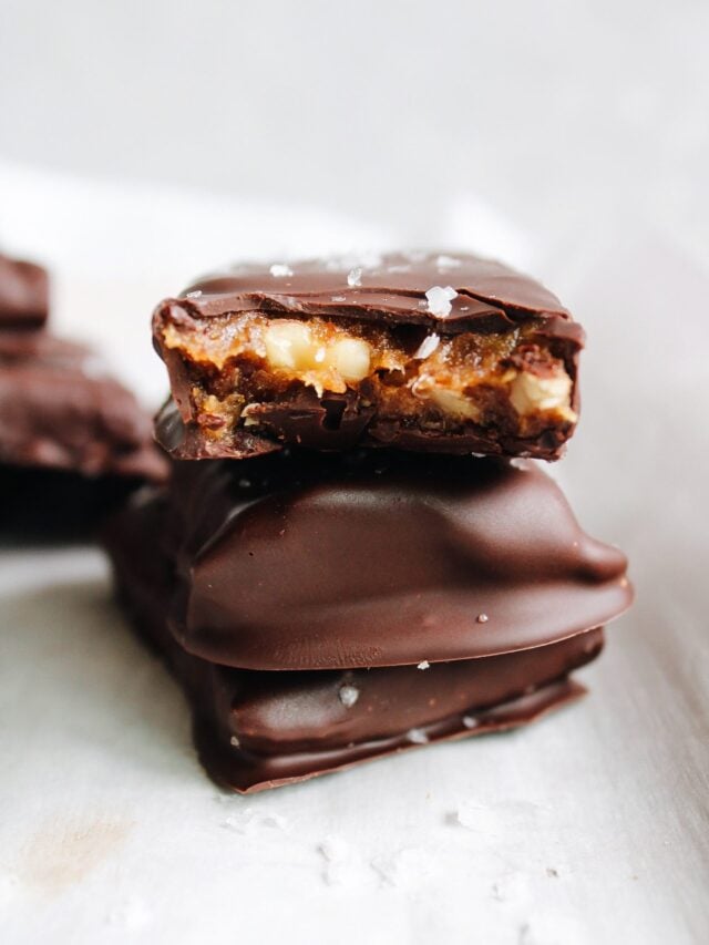 chocolate date bars stacked on a piece of parchment