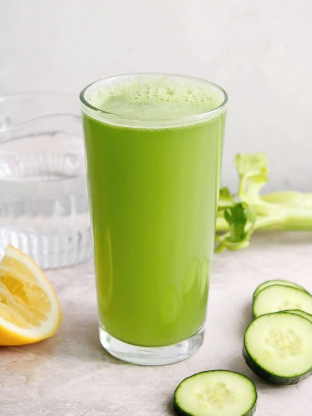 cucumber celery juice in a clear glass on a gray background