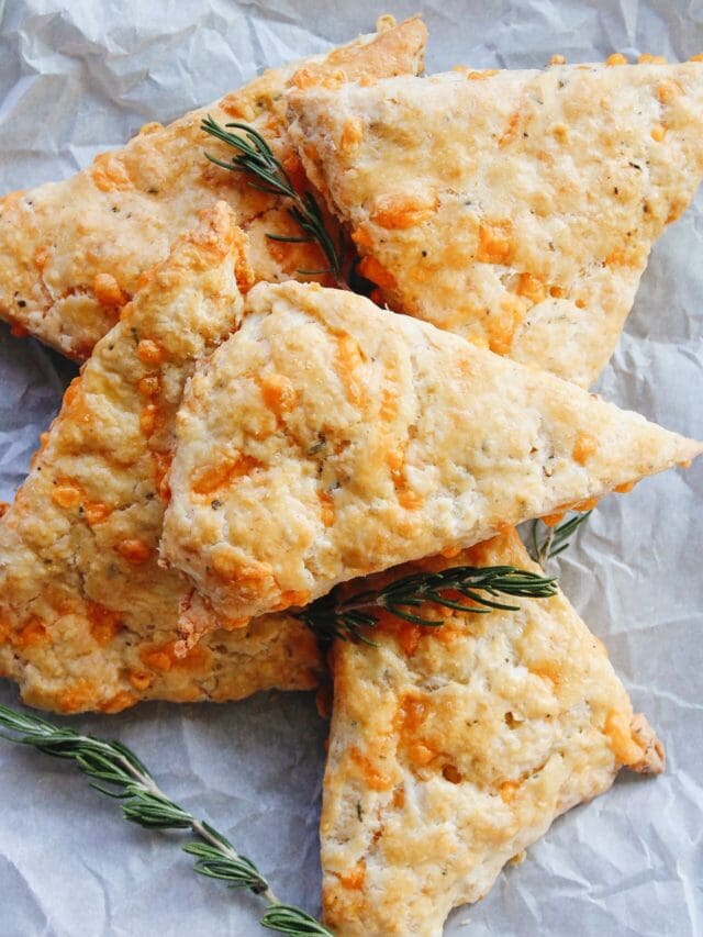 cheddar rosemary scones on white parchment paper