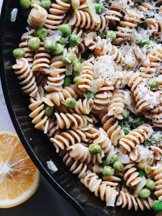 pasta with peas in a cast-iron skillet with parmesan and lemon