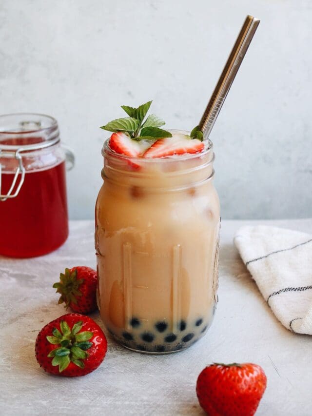 strawberry bubble tea in a mason jar with a straw and mint