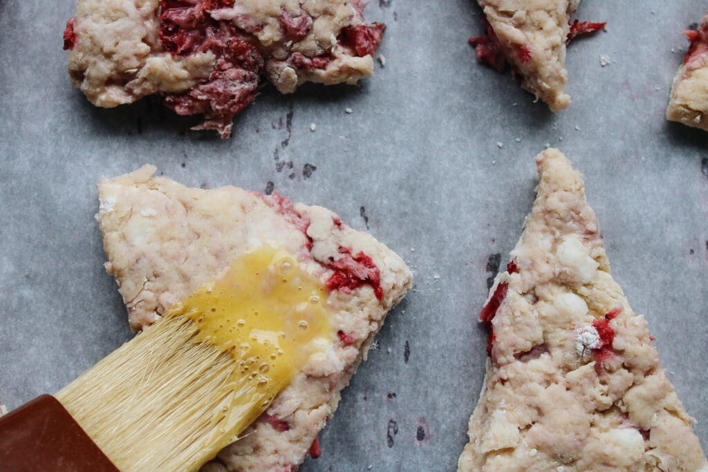 egg wash being applied to strawberry buttermilk scones