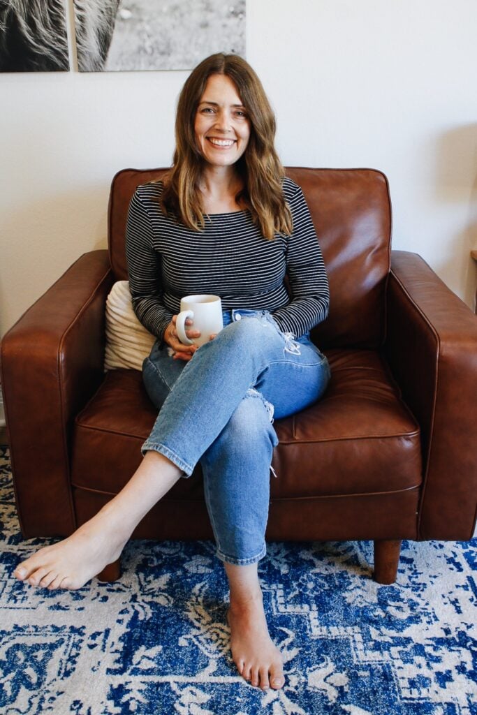 becky sitting in a brown leather chair with a cup of coffee