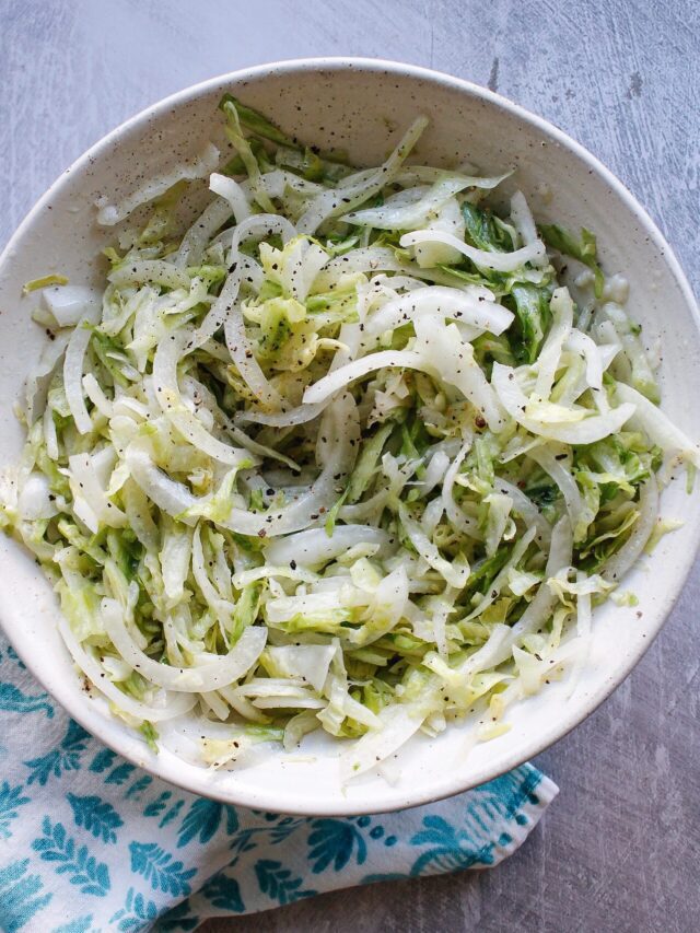 pickled lettuce in a white bowl with a blue napkin next to it