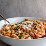 spicy pasta salad in a white bowl
