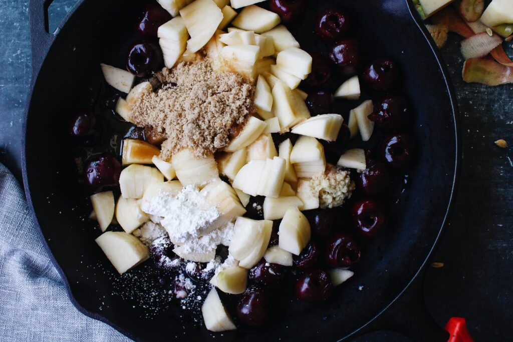 process of making cherry apple crumble. ingredients: cherries, apples, brown sugar, corn starch, grated ginger