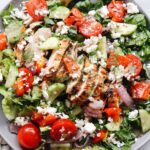 greek grilled chicken salad on a plate with a gold fork