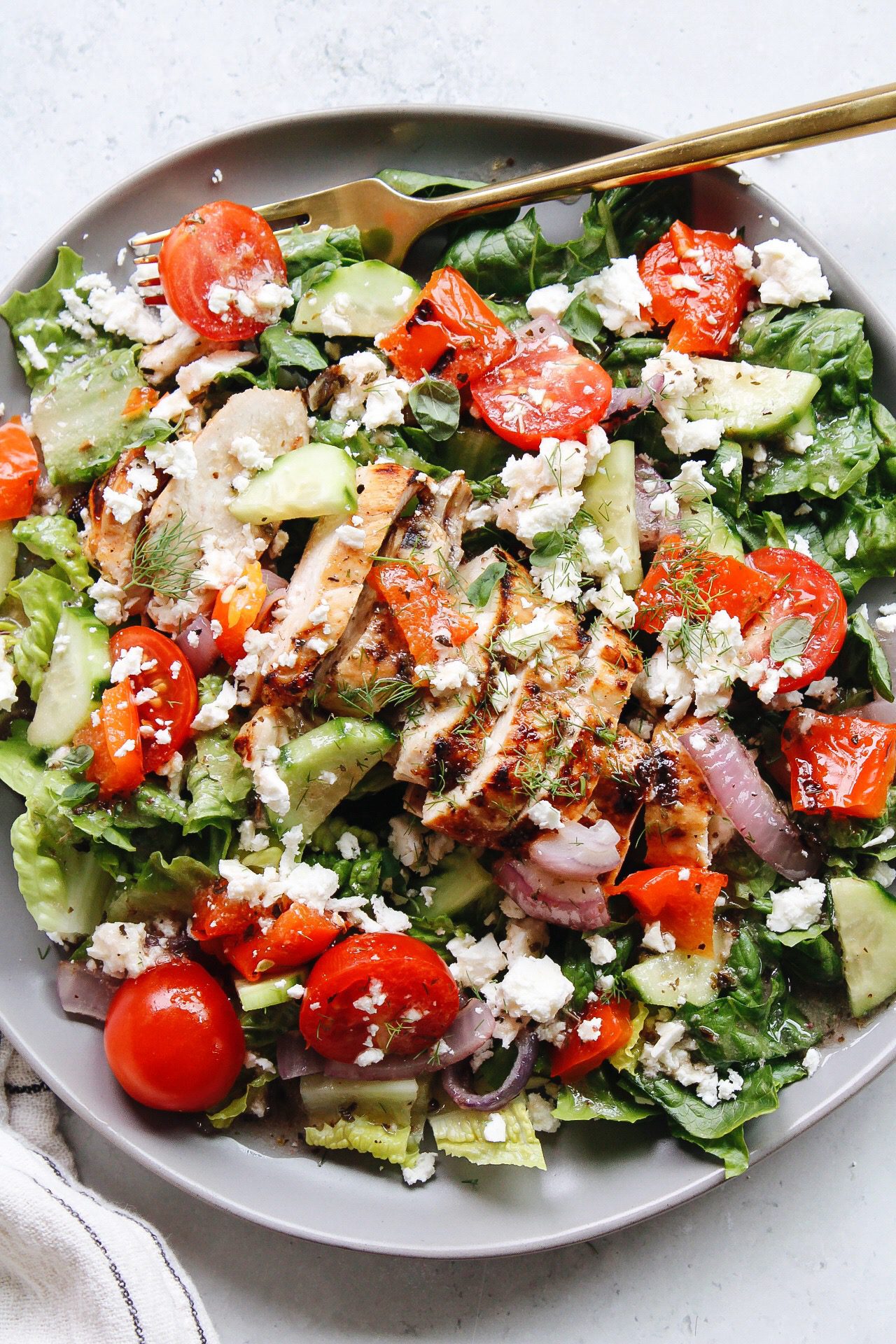 greek grilled chicken salad on a gray plate