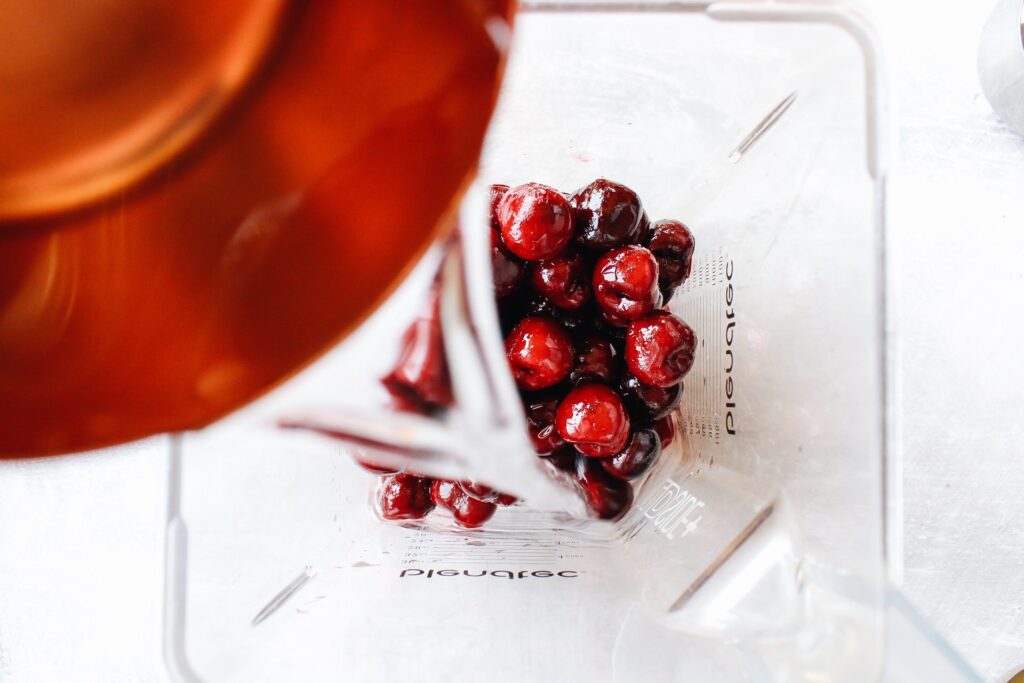 ingredients for cherry popsicles combined in a blender